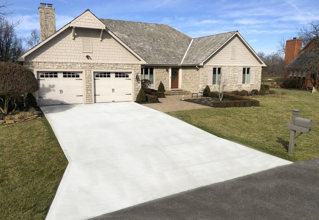 Wide concrete driveway in front of two-car garage installed by Master Campbell Concrete Company